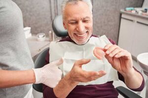 patient holding snap in dentures during consultation